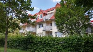 een groot wit gebouw met een rood dak bij Residenz "Zum Kronprinzen" Wohnung Nr.10 in Bad Saarow
