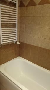Una bañera blanca en un baño con ventana. en TES Royal Plaza Apartments, en Borovets 21 fotos más