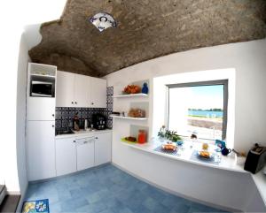 a kitchen with white cabinets and a window at Domus Fortunae B&B in Bacoli