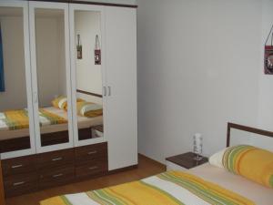 a bedroom with two beds and a large closet at Gästehaus Moleblick in Uhldingen-Mühlhofen