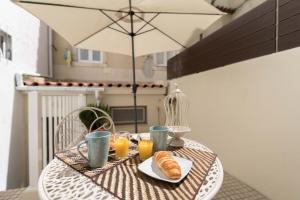 リスボンにあるTravelingToLisbon 332 - Alfamaのクロワッサンとオレンジジュースの朝食付きのテーブル