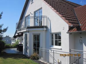 a white house with a balcony and a porch at Ferien- bzw. Zeitwohnen Burglengenfeld in Burglengenfeld