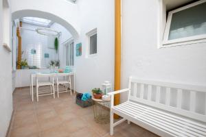 eine Veranda mit einer weißen Bank und einem Tisch in der Unterkunft Cantinho do SAL in Aveiro