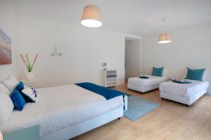 ein weißes Schlafzimmer mit einem Bett und einem Sofa in der Unterkunft Cantinho do SAL in Aveiro