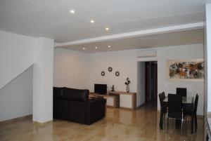 a living room with a black couch and a table at Apartaments el tiet in Sant Carles de la Ràpita