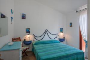 una camera con letto e piumone blu di Maestrale BFlat - Klodge a Olbia