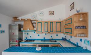 una cucina con armadi in legno e pavimento piastrellato blu di Maestrale BFlat - Klodge a Olbia
