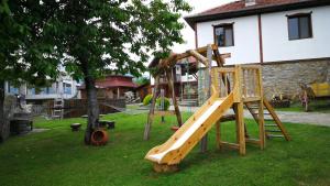 un patio con un parque infantil con un tobogán de madera en Guest House Stoilite, en Boazat