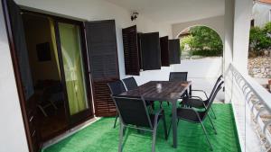 ein Esszimmer mit Tisch und Stühlen auf einem Balkon in der Unterkunft Apartmani Laura in Trogir