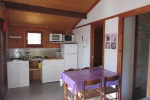 a kitchen with a table and a kitchen with white appliances at Le Verger des Ascarines in Corneilla-de-Conflent