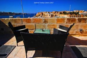 a table and chairs on a patio with a view of a city at Twenty Antika in Birgu