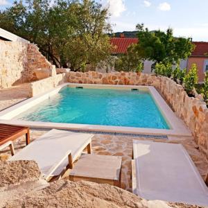 a large swimming pool in a stone wall at Villa Cherie in Sutomišćica
