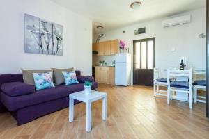 a living room with a purple couch and a table at Apartment Placido Krk in Krk