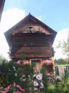 ein kleines Holzgebäude mit Blumen davor in der Unterkunft Rettlhof in Sankt Peter am Kammersberg