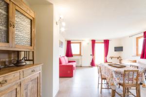 eine Küche und ein Wohnzimmer mit einem Tisch und einem roten Sofa in der Unterkunft La Casa di Alfredo e Virginia in Aosta