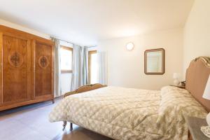 ein Schlafzimmer mit einem Bett und einem Holzschrank in der Unterkunft La Casa di Alfredo e Virginia in Aosta