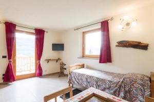 ein Schlafzimmer mit einem Bett und einem Fenster mit roten Vorhängen in der Unterkunft La Casa di Alfredo e Virginia in Aosta
