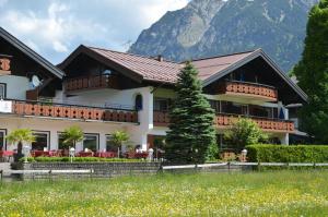 a house in front of a mountain at Hotel Cafe Fuggerhof in Oberstdorf