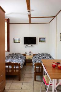 een kamer met twee bedden en een tafel en een televisie bij Apartmani Rakic in Sutomore