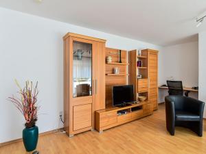 ein Wohnzimmer mit einem hölzernen Entertainment-Center mit einem TV in der Unterkunft Ferienwohnung Schliestädt-Görge in Lindau