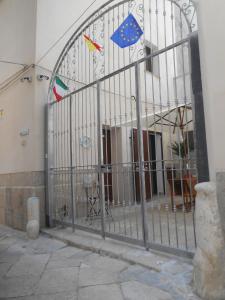 un cancello con le bandiere di fronte a un edificio di La Corte Dei Naviganti a Trapani