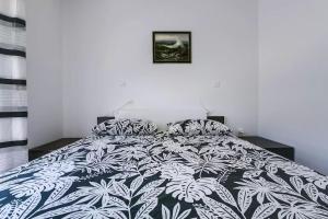 a bedroom with a bed with a black and white comforter at Apartment Vitalia 2+2 in Poreč