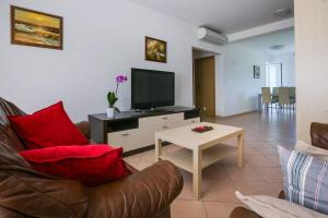 a living room with a couch and a tv and a table at Apartment Vitalia 2+2 in Poreč