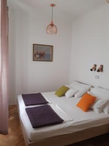 łóżko z kolorowymi poduszkami w pokoju w obiekcie Apartment Nada w mieście Opatija