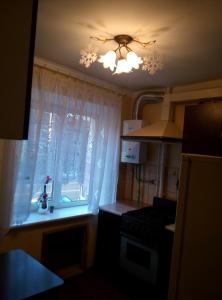 カリーニングラードにあるTeatralnaya Apartmentの窓とシャンデリア付きのキッチン