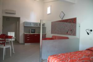 a bedroom with a bed and a table and a kitchen at Iride Guest House in Oristano