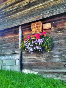 ein Blumengestell an der Seite einer Holzwand in der Unterkunft Rettlhof in Sankt Peter am Kammersberg