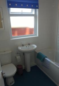 baño con lavabo y aseo y ventana en Sandy Cottage en Clacton-on-Sea