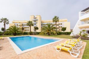 a swimming pool with lounge chairs and a building at Casa Harland by Seewest in Albardeira