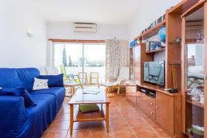 a living room with a blue couch and a tv at Casa Harland by Seewest in Albardeira