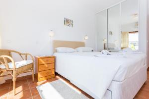 a bedroom with a large white bed and a chair at Casa Harland by Seewest in Albardeira +17 photos