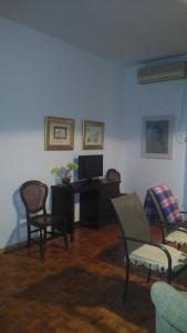 a living room with a desk with a tv and chairs at Piso centro de Cordoba in Córdoba