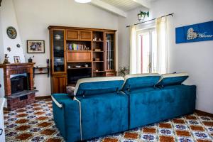 a blue couch in a living room with a fireplace at Casa Il Negrito in Massa Lubrense