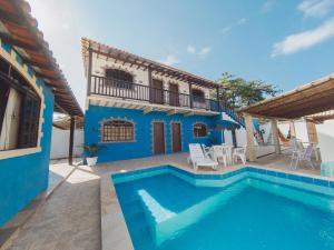 a villa with a swimming pool and a house at Pousada MK TOUR in Pedra de Guaratiba