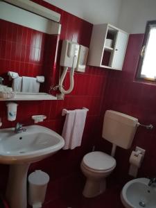 サント・ステーファノ・ディ・カドーレにあるAlbergo Krissinの赤いバスルーム(トイレ、洗面台付)