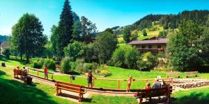 eine Gruppe von Menschen, die auf einer Bank auf einem Feld sitzen in der Unterkunft Schlosserhaus Appartements in Wagrain