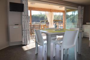 a kitchen and dining room with a table and chairs at Chalet 2 chambres en Bois dans les landes n34 in Tosse