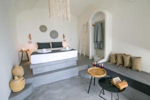 una camera con letto, tavolo e sedie di Santorini Villas a Vourvoúlos Altre 37 foto
