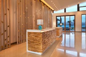a lobby with a stone counter with a lamp on it at The Setai Sea Of Galilee in Ein Gev
