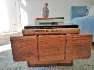 a stack of books on top of a wooden coffee table at Kleinod am Park - Zentrum-Südost in Leipzig