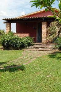 una casa rossa con un sentiero di fronte di Agriturismo Castro a Ischia di Castro