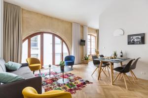 uma sala de estar com um sofá, uma mesa e cadeiras em Les Suites de Saint Amand em Bordeaux