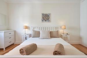 ein weißes Schlafzimmer mit einem weißen Bett mit zwei Lampen in der Unterkunft Príncipe Charming in Lissabon