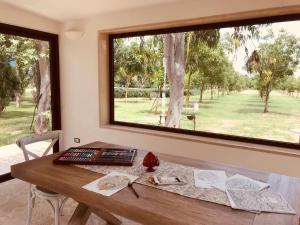 a room with a table with a large window at Tenuta Monaci La Murra in Carmiano
