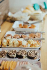 una mesa con varios platos de repostería. en Pousada MK TOUR, en Pedra de Guaratiba