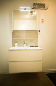 een badkamer met een wastafel en een plafondventilator bij Gîtes du tellin in Couvin